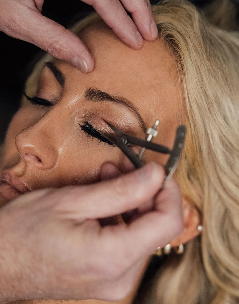 A close up shot of a woman's eyelids being measured with a caliper during a cosmetic procedure. - Eyelid Surgery Blepharoplasty in Carmel, IN